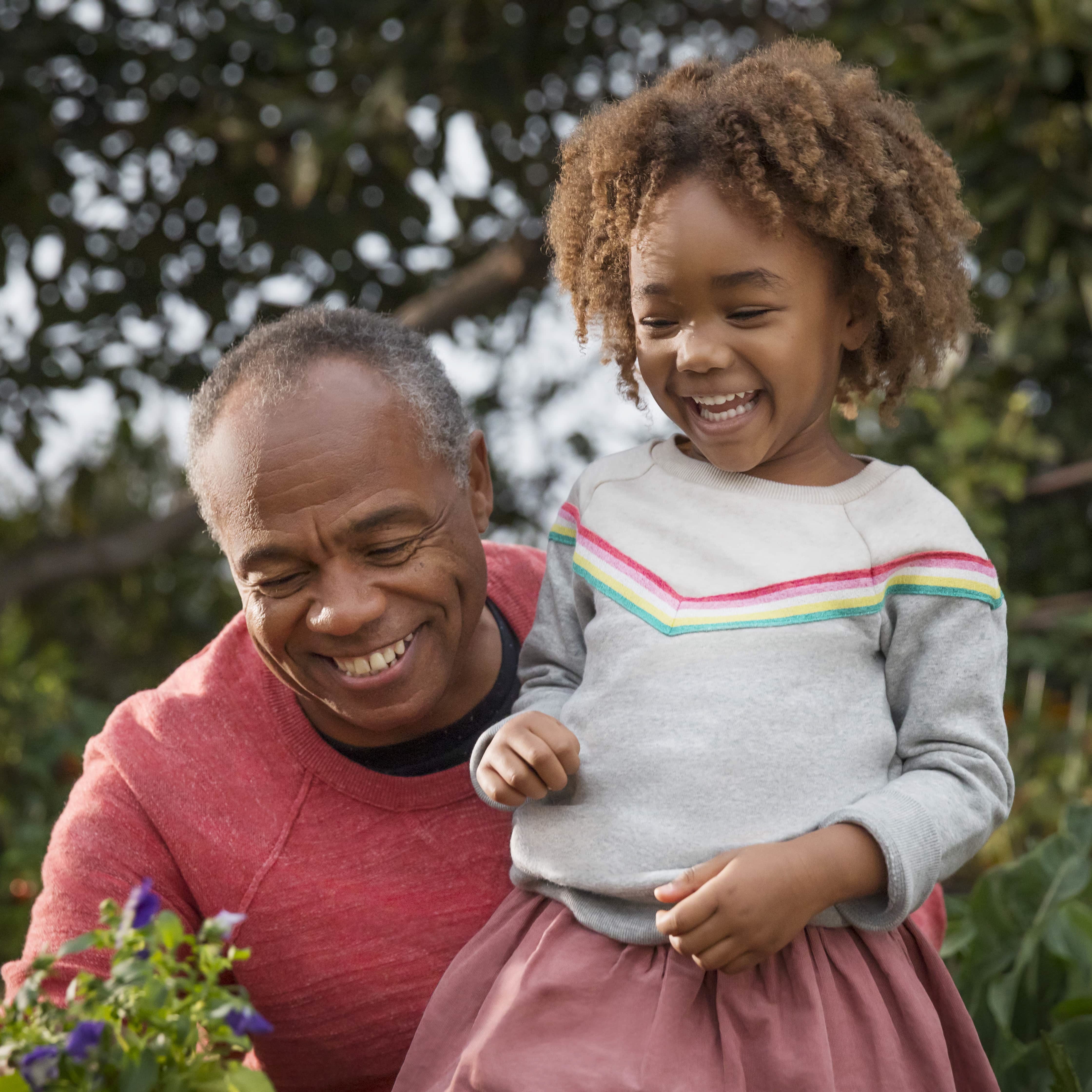 Older man and child laughing in the garden
