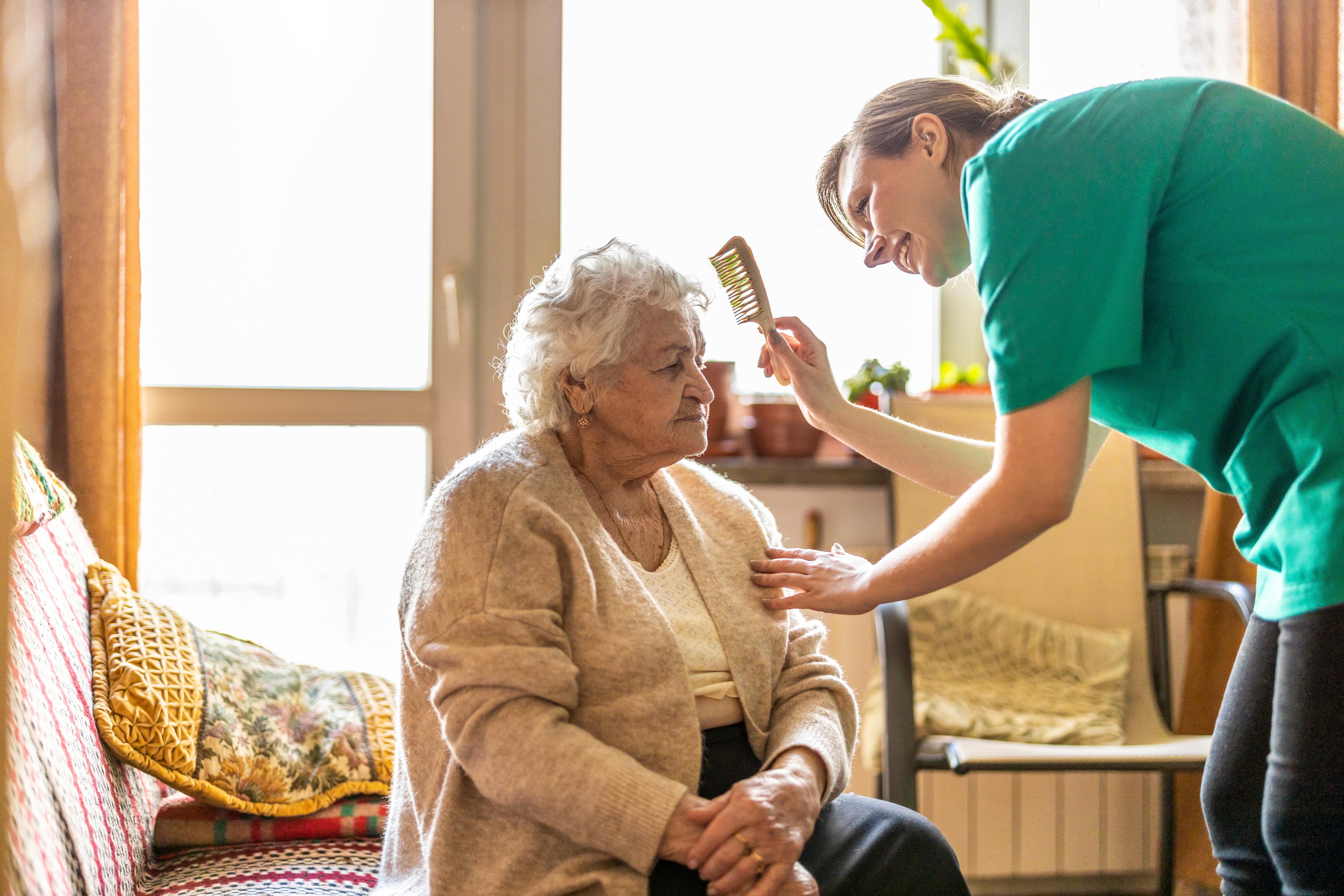 A caretaker brusher a patients hair