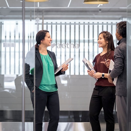 Three colleagues talking together in office