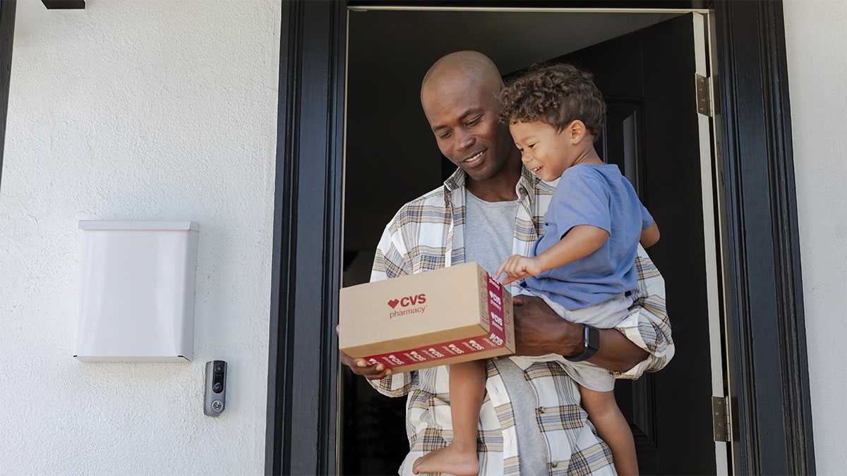 Father and son holding CVS Pharmacy package