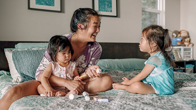 Mother and two daughters sitting in bed